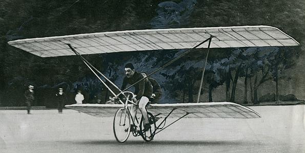 Ein Mann sitzt auf einem Fahrrad, das Segelflügel hat