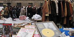 Bild von Verkaufsstand am Flohmarkt beim Naschmarkt. Angeboten werden Pelzmäntel, Elvis-Merchandise-Artikel und diverser Krims-Krams.