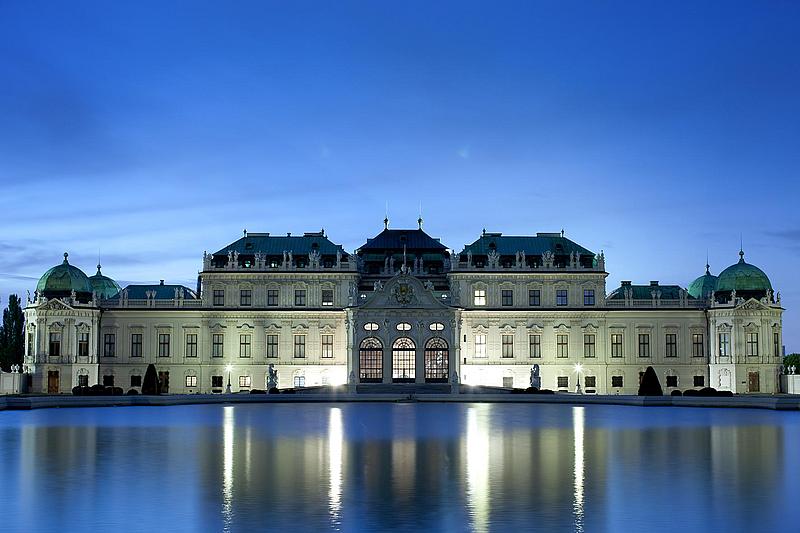 Das Schloss Belvedere spiegelt sich abends auf der Oberfläche des Teichs.
