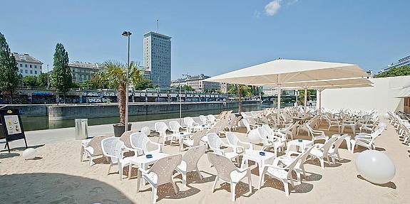 Strandterasse mit vielen Stühlen und Sonnenschirmen an einem schönen Tag am Donaukanal