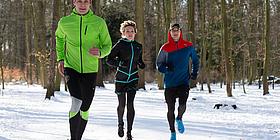 3 sportliche Läufer im Schnee
