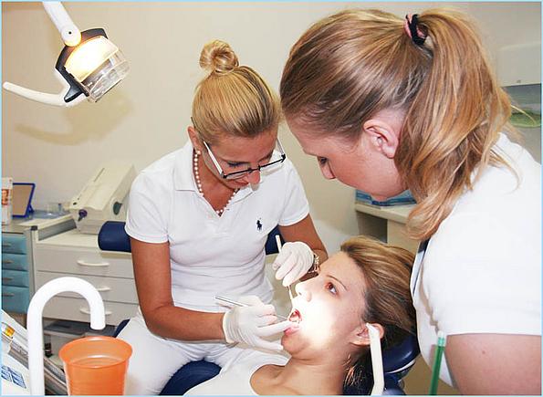 Zahnärztin DDr. Piotrowski mit Zahnarzthelferin bei einer Zahnbehandlung an einer Patientin.