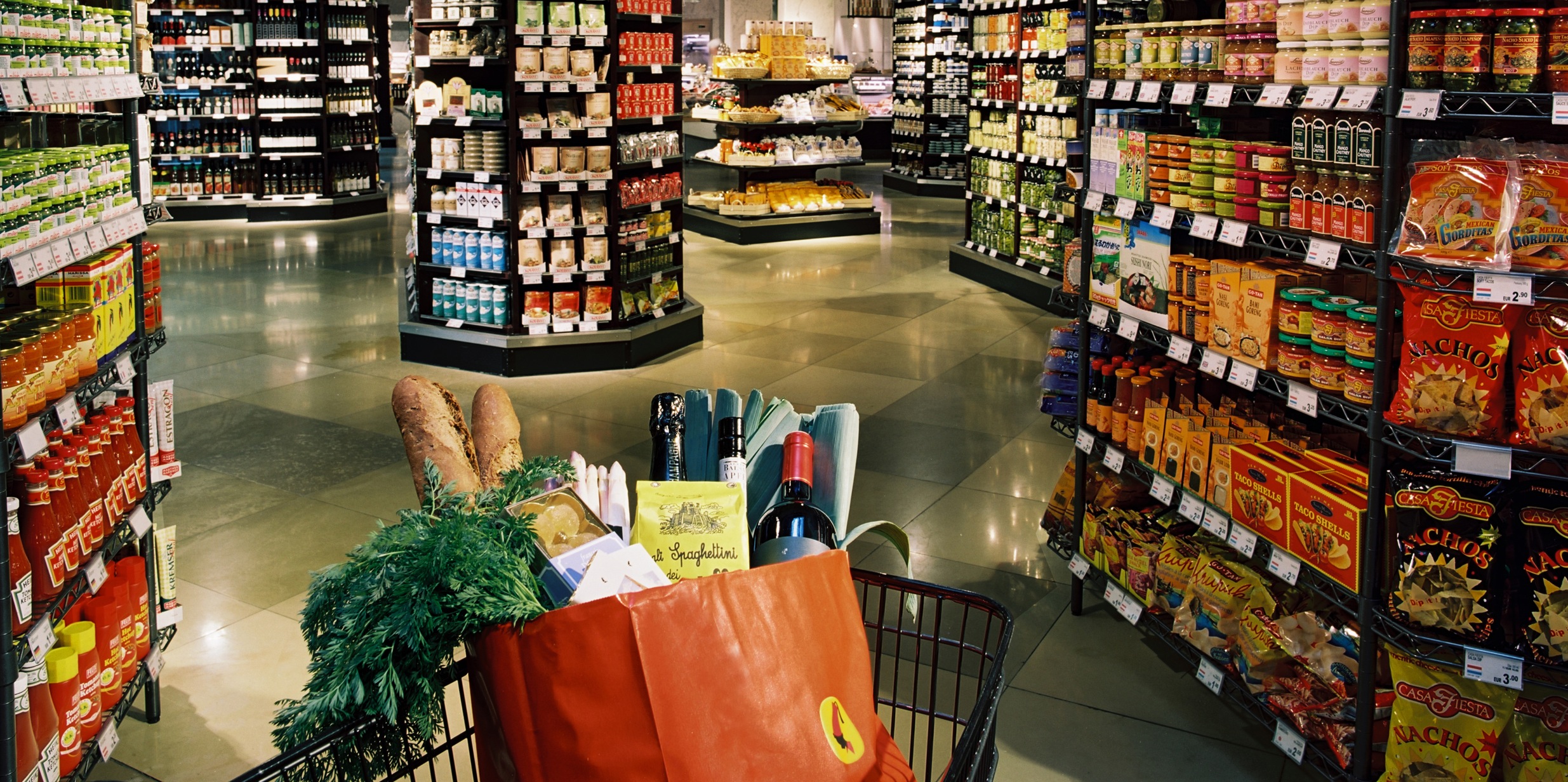Einkaufswagerl mit vollem Einkaufssackerl von Julius Meinl am Graben zwischen Supermarktregalen 