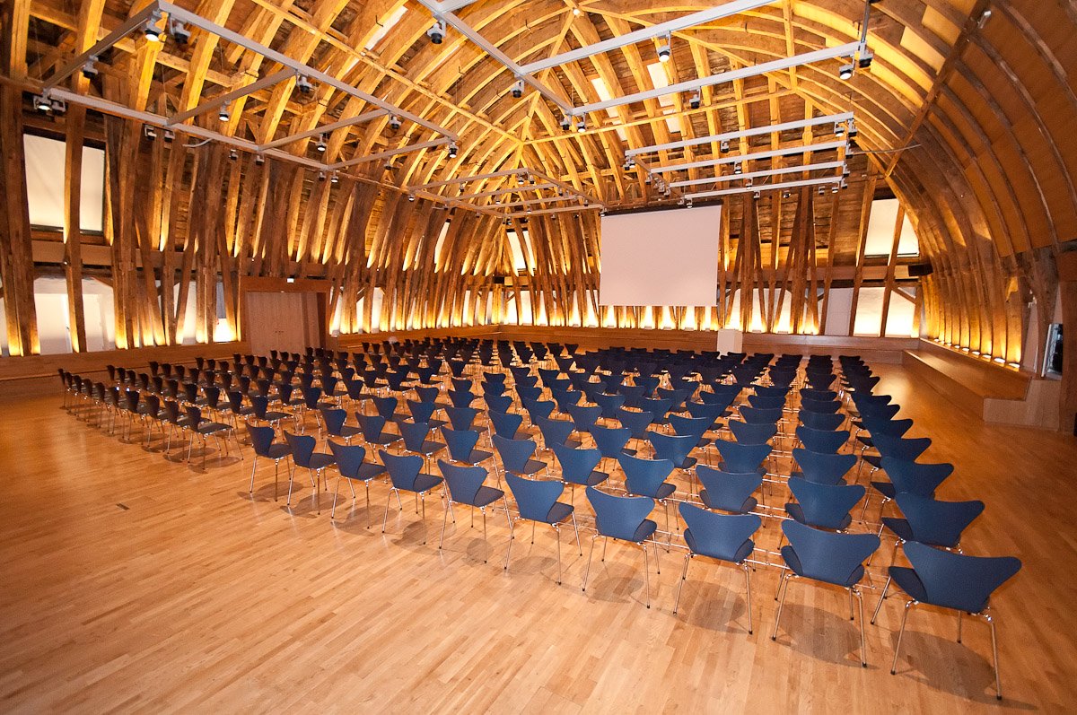 Ein großer Saal mit Parkettboden und einer Holzkuppel