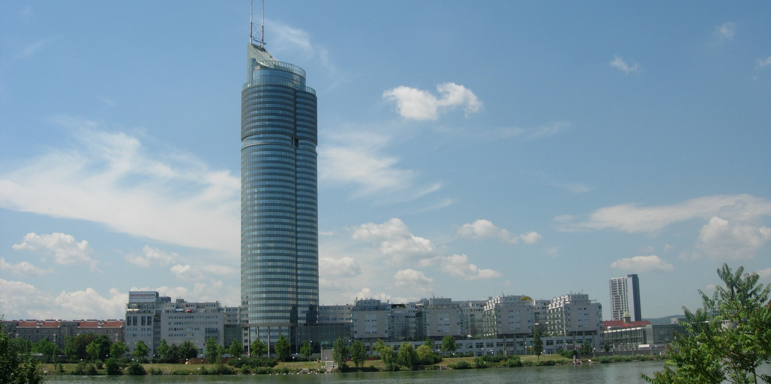 Blick auf ein bebautes Stadtgebiet in dem im Zentrum ein großer Wolkenkratzer in die Höhe ragt.