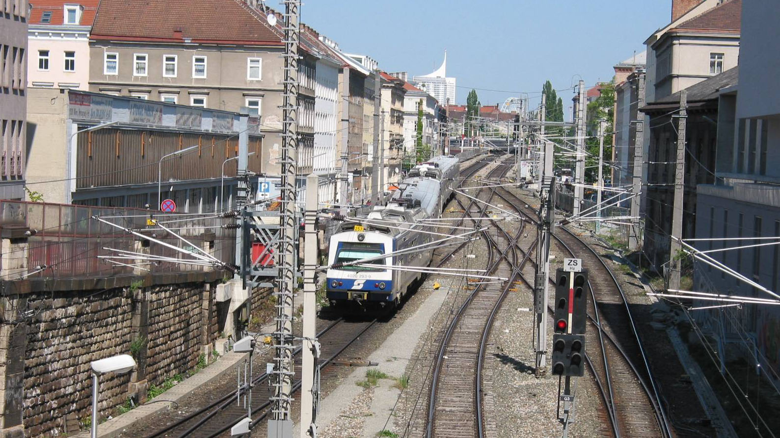 Zug der Wiener S-Bahn fährt zwischen Häuserzeilen.