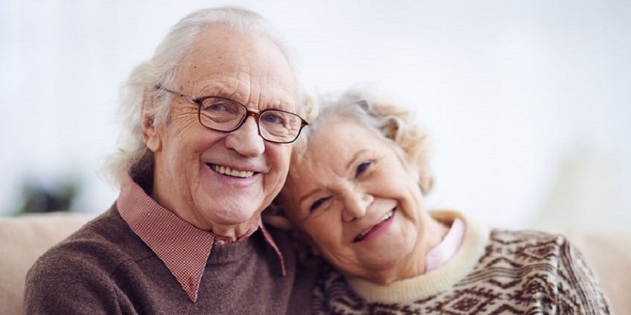 Älteres Paar lächelt glücklich in die Kamera