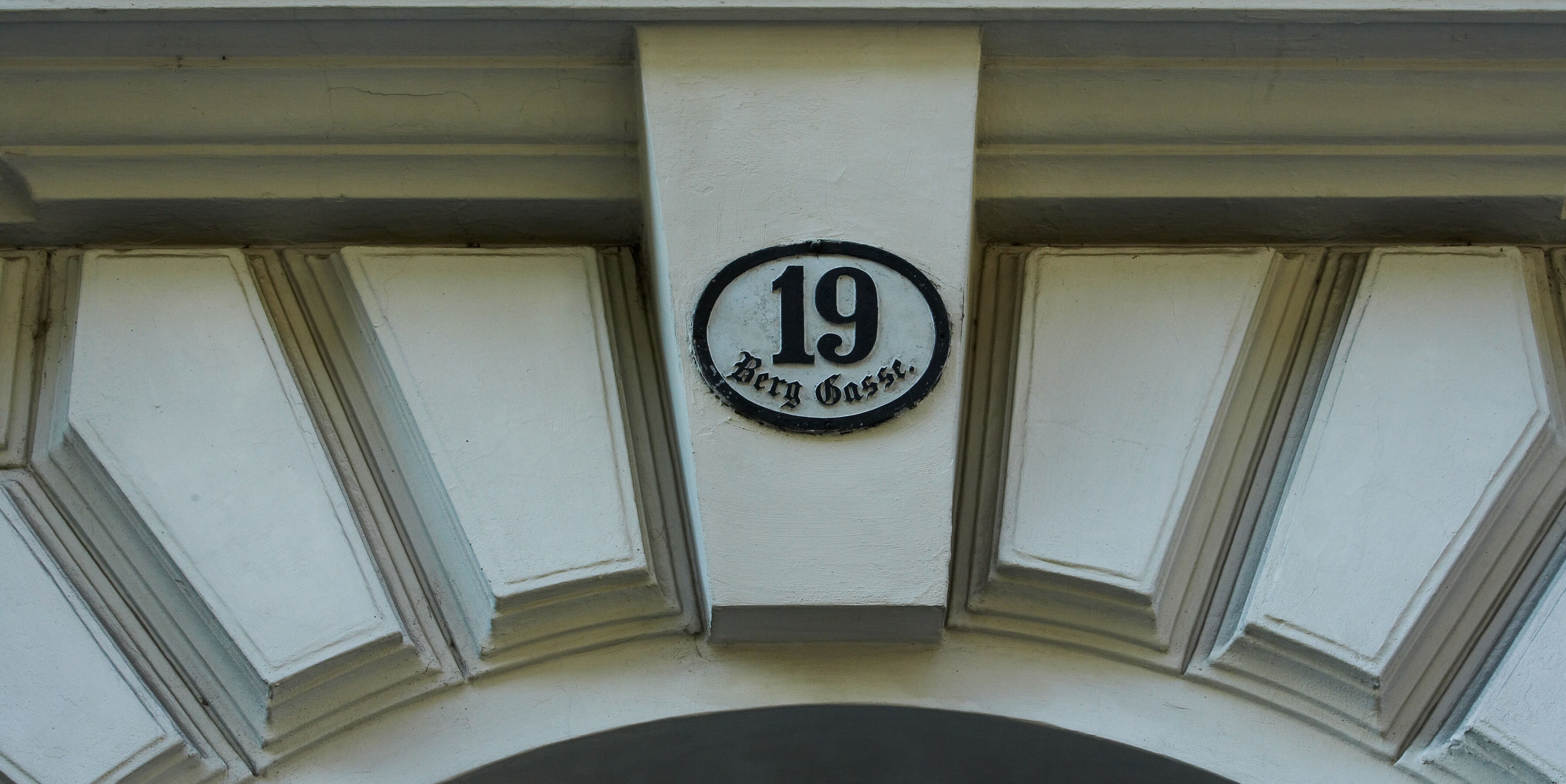 Ausschnitt des Torbogens eines Hauses mit dem Hausnummernschild Nummer 19