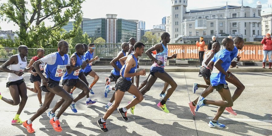 Marathon-Teilnehmerinnen und Teilnehmer laufen an der Urania vorbei
