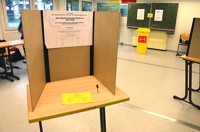Wahlkabine Österreich, sehr schlichter brauner Tisch