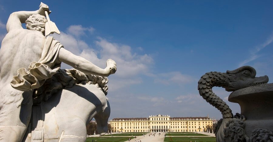 Eine Statue im Vordergrund, das Schloss Schönbrunn im Hintergrund
