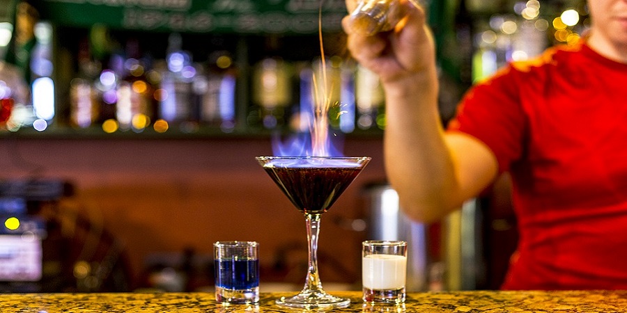 Cocktailglas auf Bar das angezündet wird.