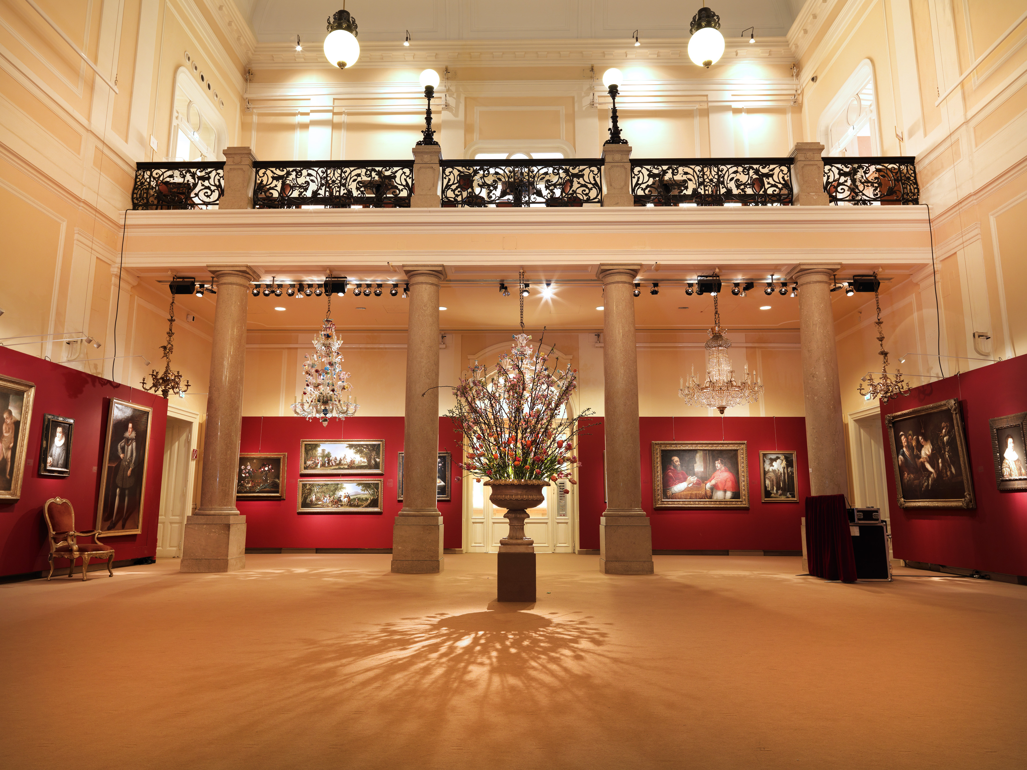 Innenraum des Dorotheum Wien mit Schaustellung von Bildern auf roter Rückwand, Gallerie und Säulen