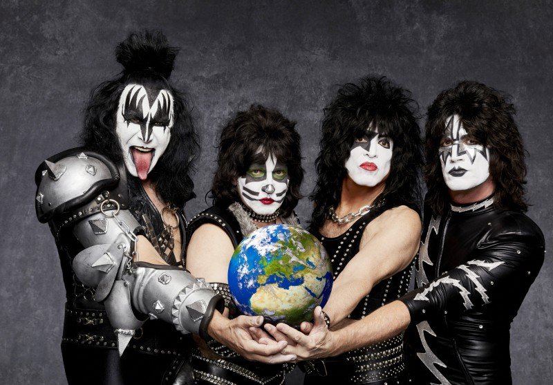 Die vier Bandmitglieder von Kiss halten gemeinsam einen Globus bzw. die Welt in Händen