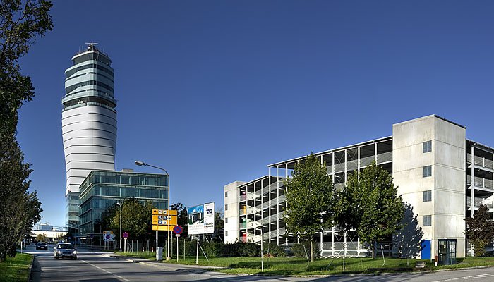 Der Tower des Flughafen Wiens im Hintergrund. Im Vordergrund NH Hotel und Parkhaus 4.