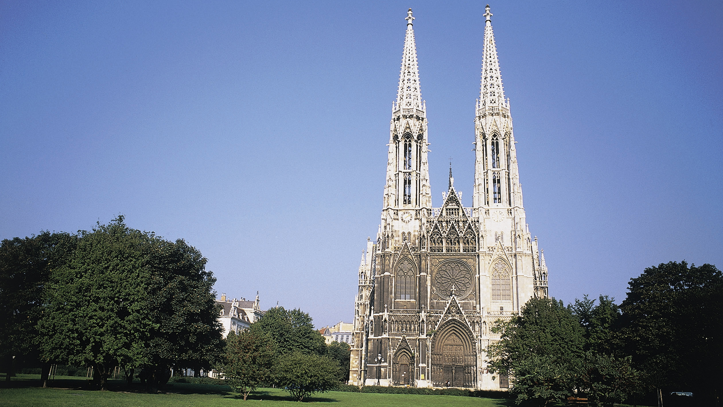 Frontalansicht der Votivkirche in Wien vom Sigmund Freud Park aus gesehen.