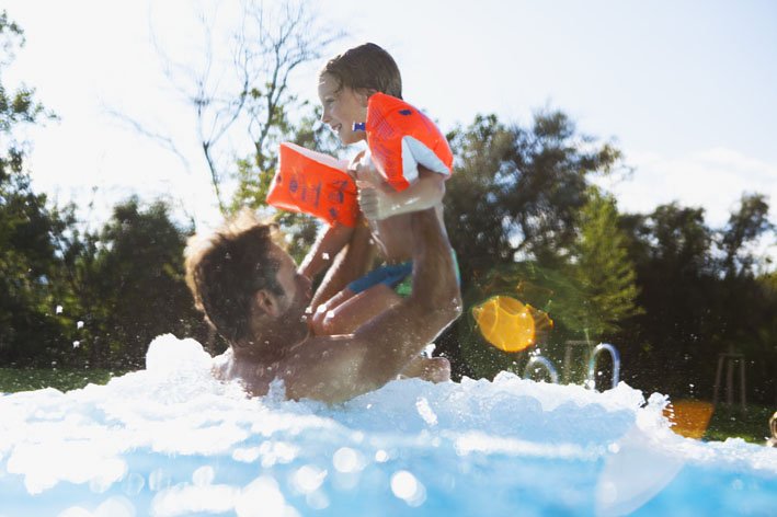 Vater und Kind spielen im Pool