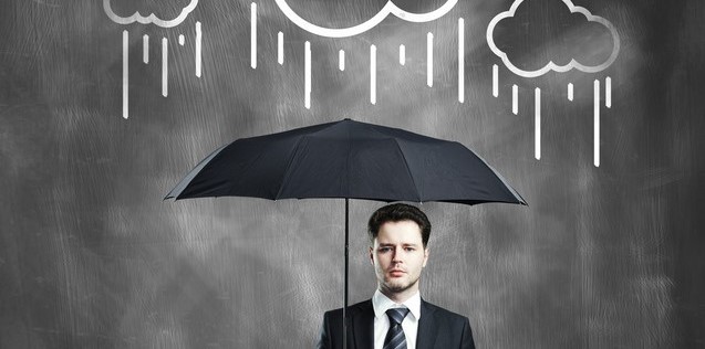 Mann im Anzug und mit Regenschirm unter Wolken