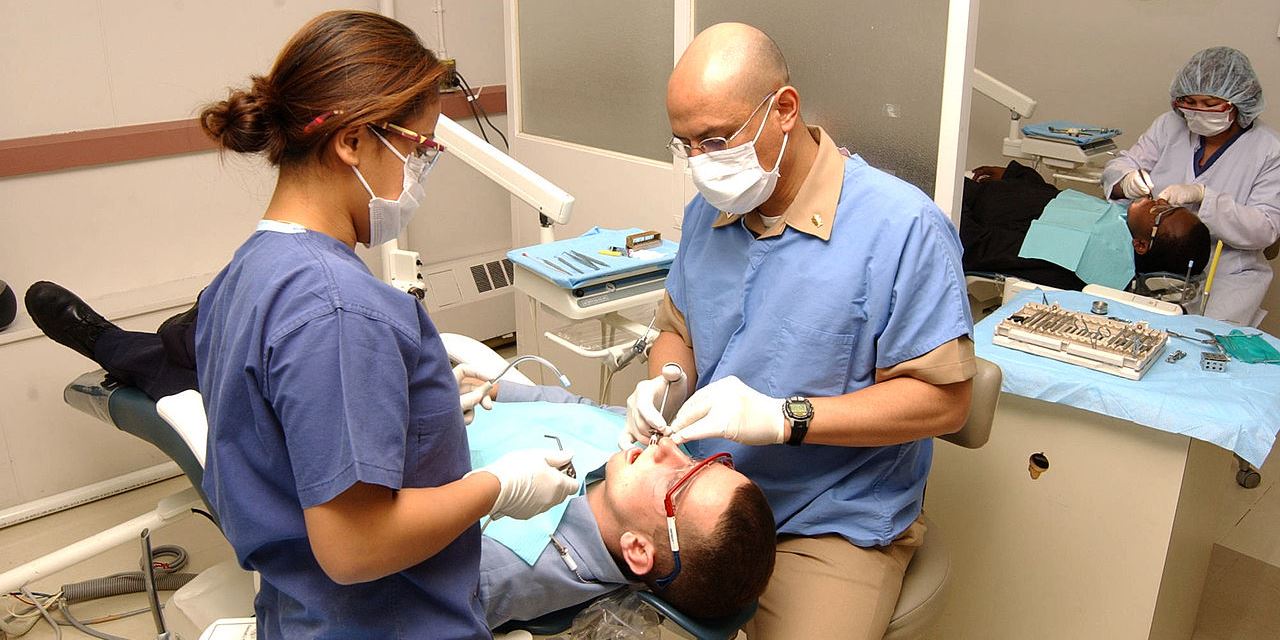 Zahnarzt und Assistentin behandeln Patienten