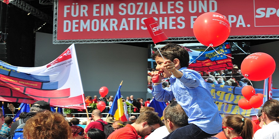 kleines kind auf schultern am 1. mai mit SPÖ luftballon