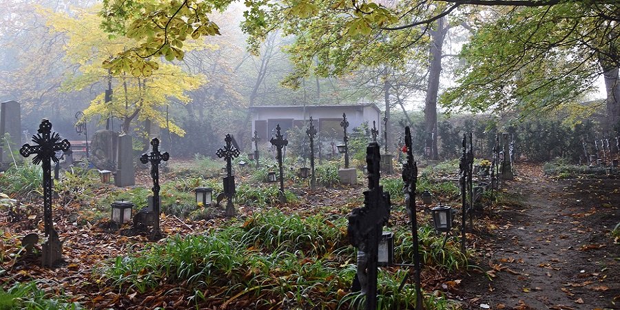Mystischer Friedhof, schwarze Kreuez an einem düsteren Herbsttag