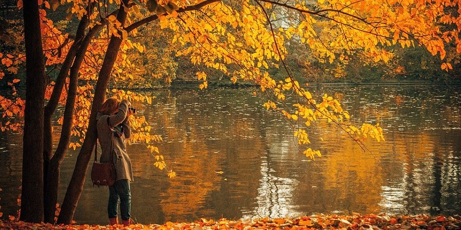Frau am See in Herbstkulisse