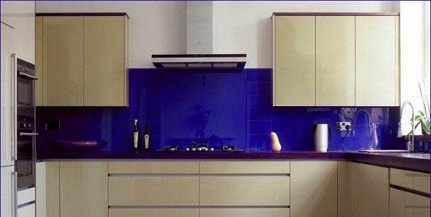 Blau lackierte Glas-Küchenrückwand in einer Küche mit weißen Frontseiten