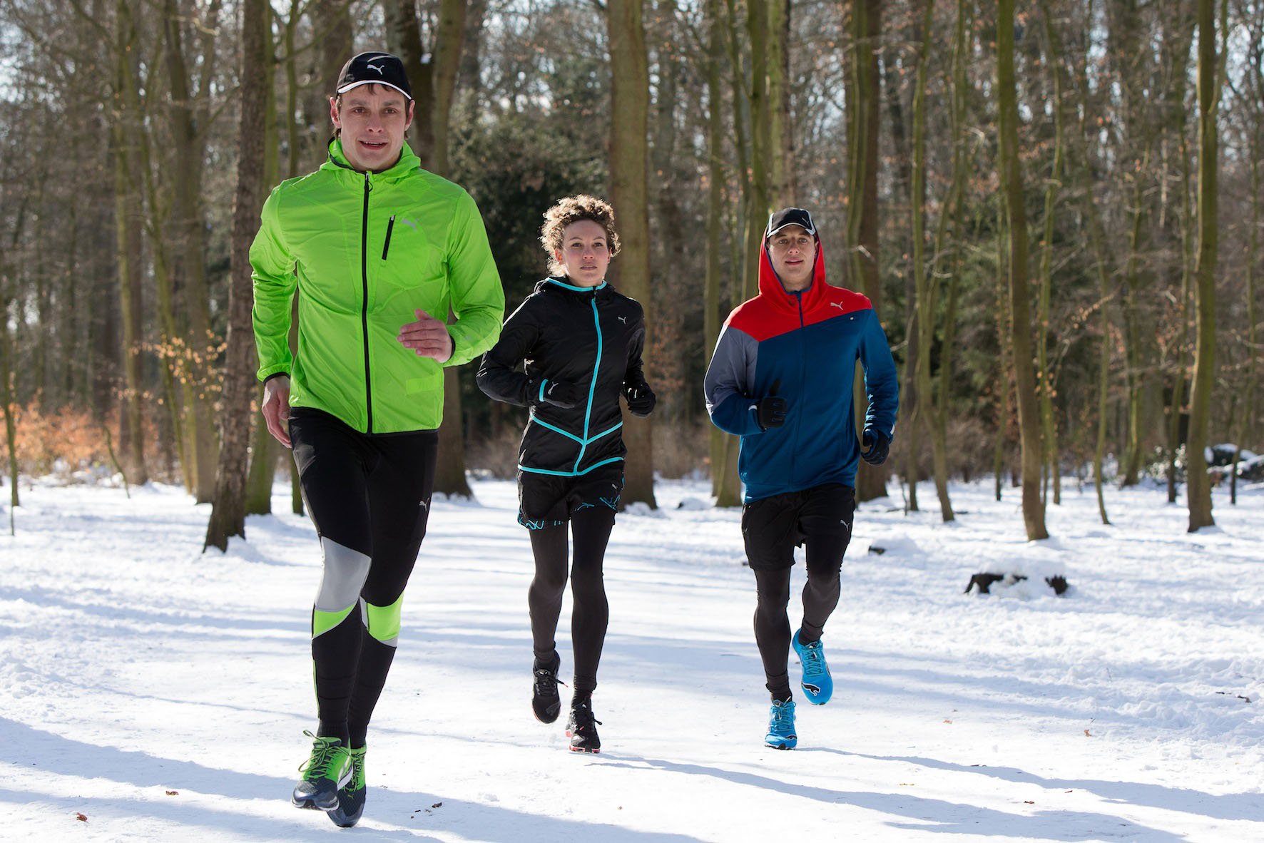 3 sportliche Läufer im Schnee
