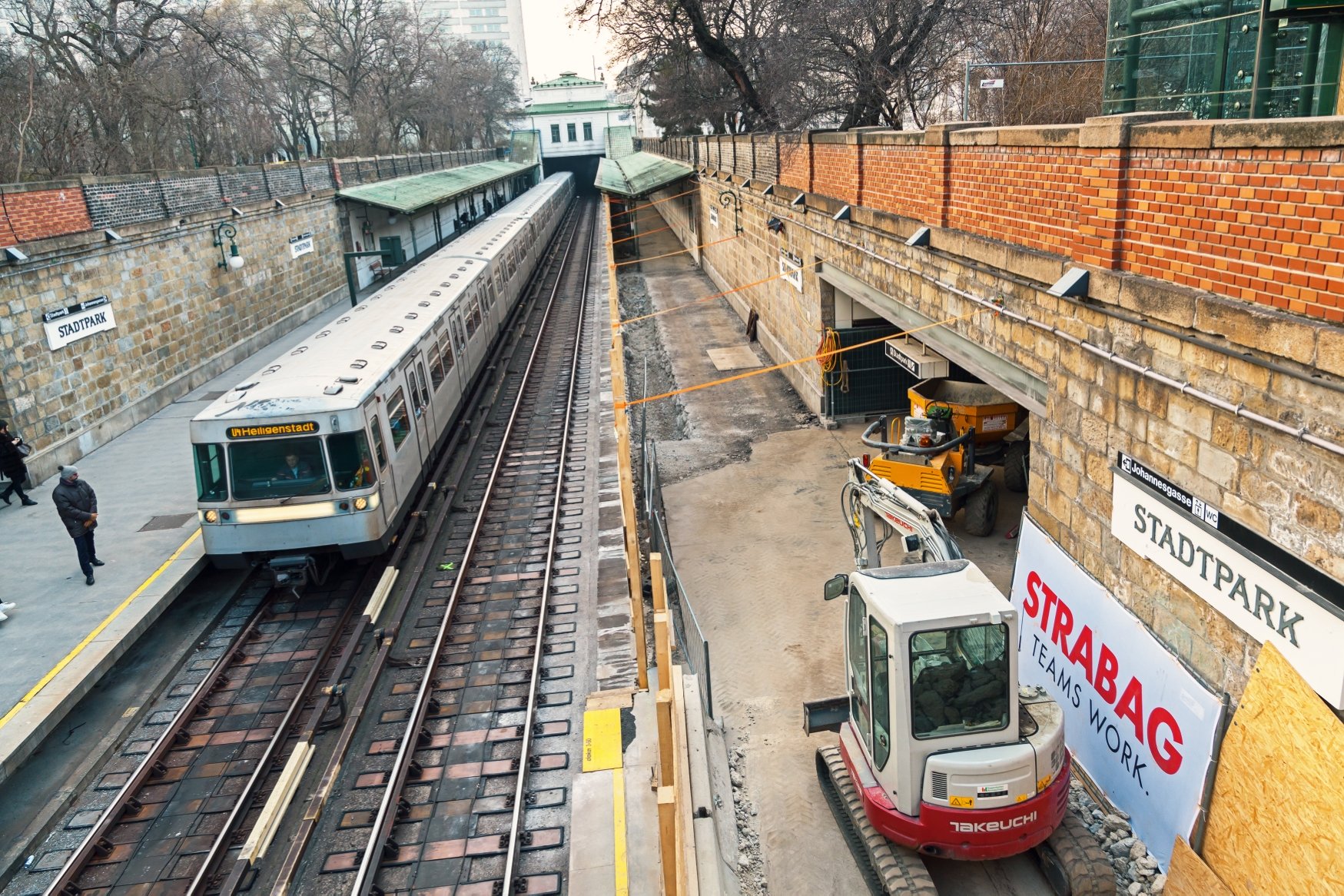 Die Baustelle der Station Stadtpark. Eine U-Bahn fährt durch die Station, welche gerade renoviert wird. 