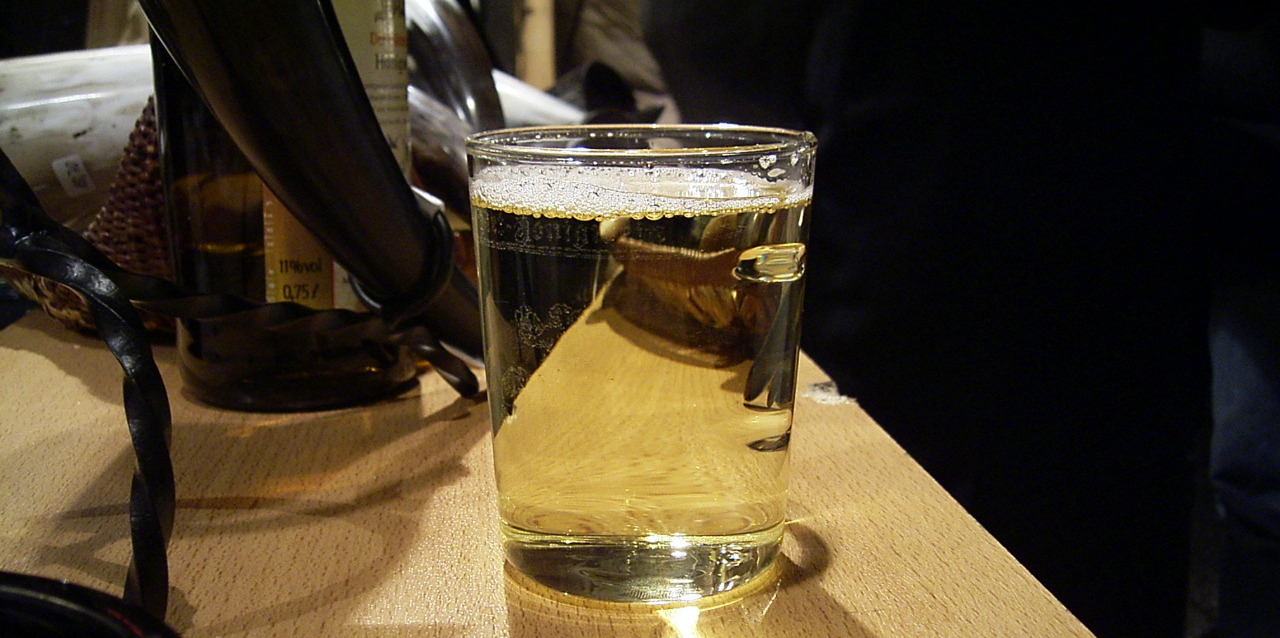 Glas mit Honigwein darin auf einer Tischplatte