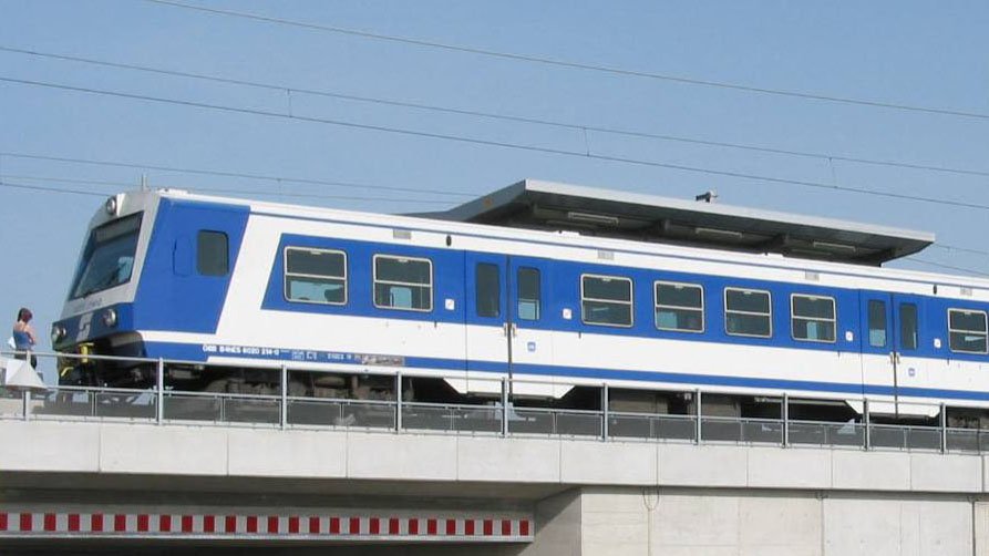 Wiener Schnellbahn fährt über Brücke.