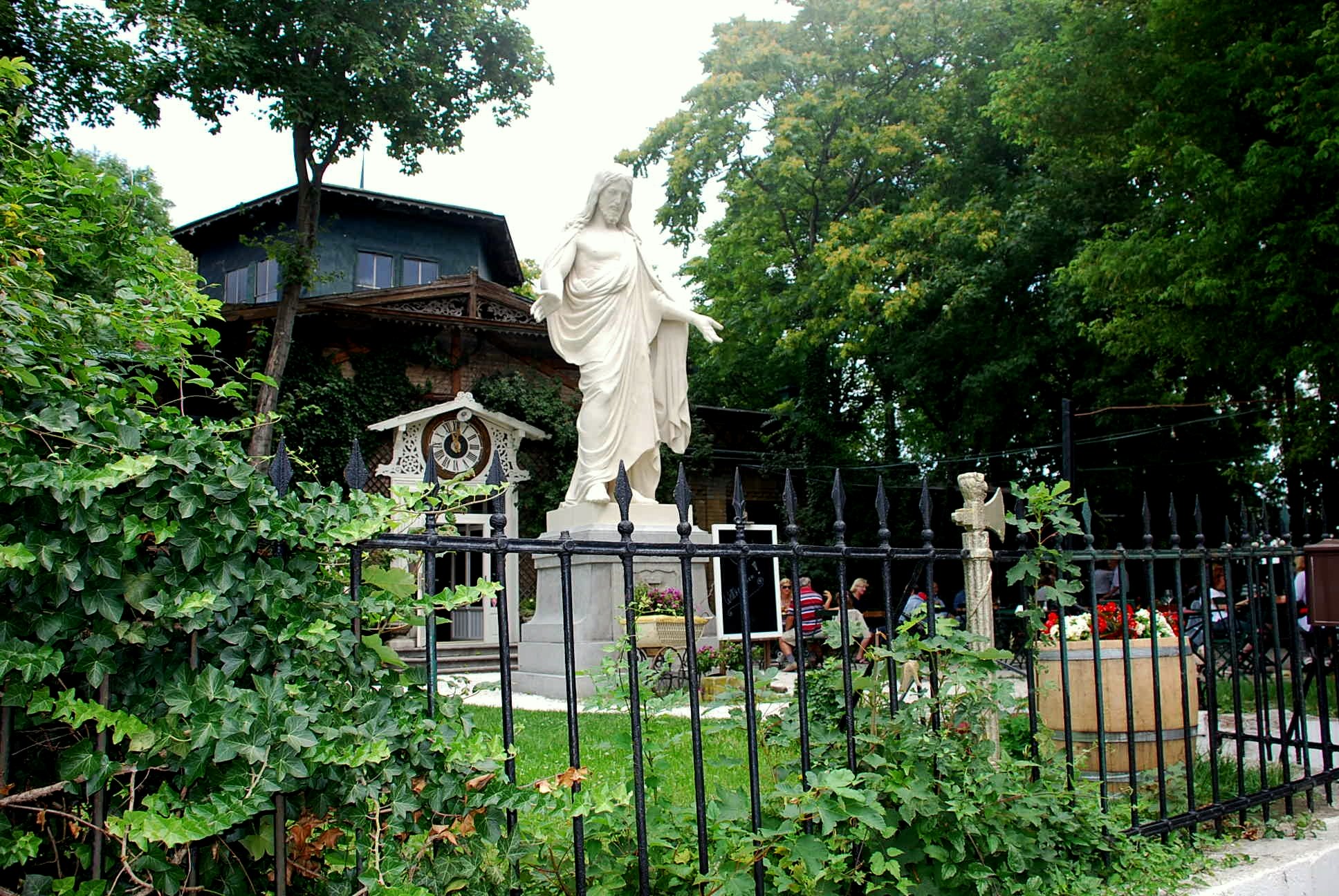 Christus Statue im Garten vor dem Schloss Concordia schräg vond er Seite über den Gusseisenzaun hinweg zu sehen