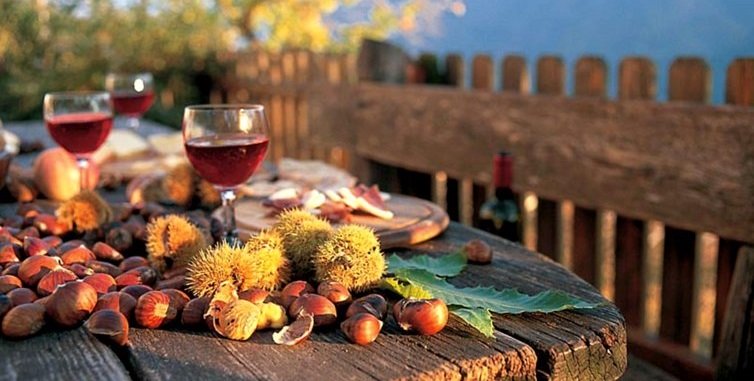 Kastanien und roter Wein auf einem Holztisch 