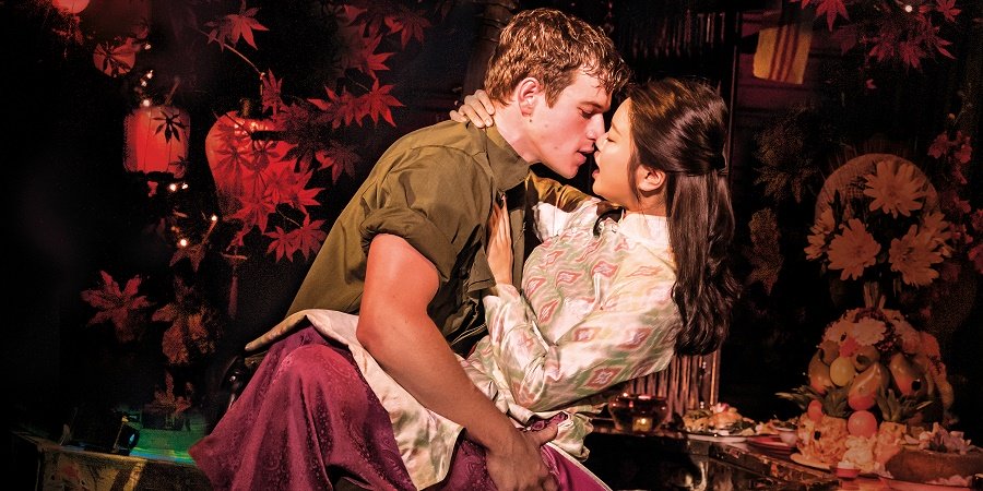 Eine Frau und ein Mann küssend vor roten Lampions