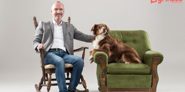 Mann auf Stuhl links, Hund in Vinagesessel rechts