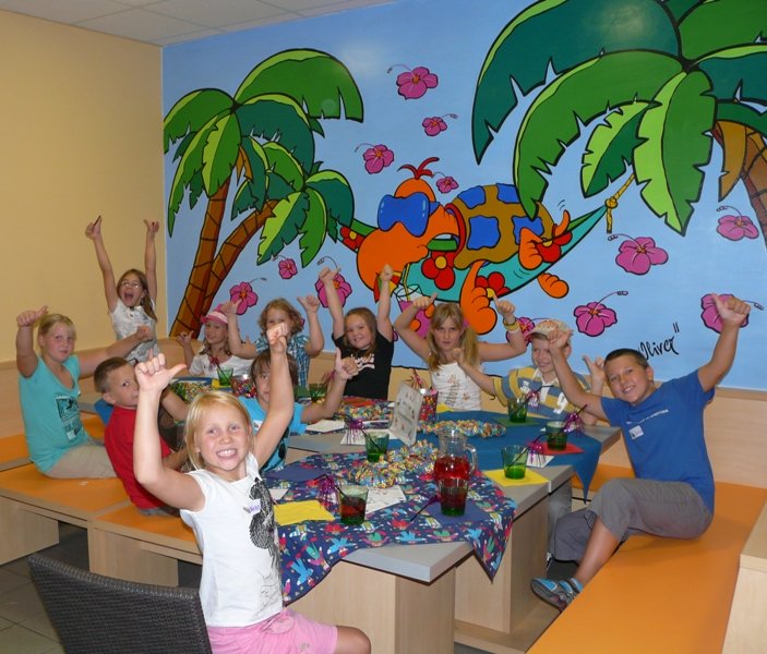 Jubelnde Kinder um einen Tisch versammelt bei einem Geburtstagsfest im Haus des Meeres