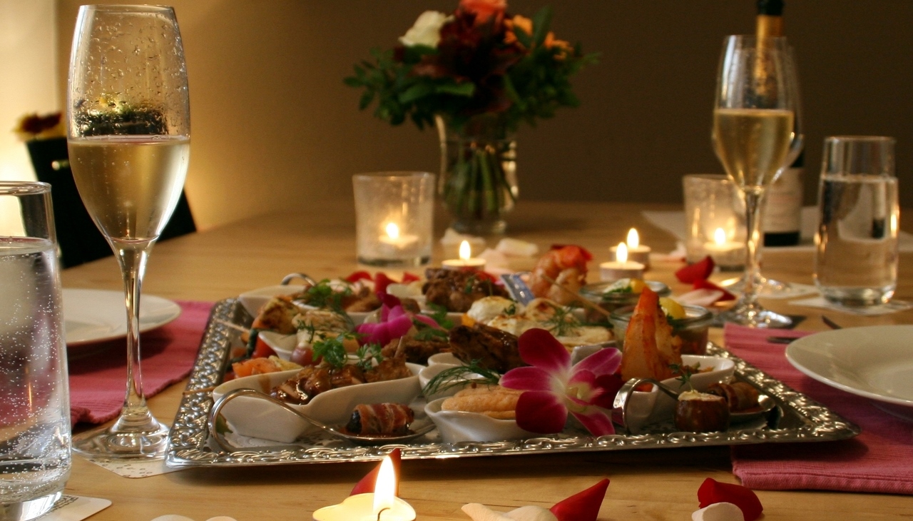 Romantisches Abendessen mit Kerzen, Blumen und Sektgläsern, sowie einer Platte für 2