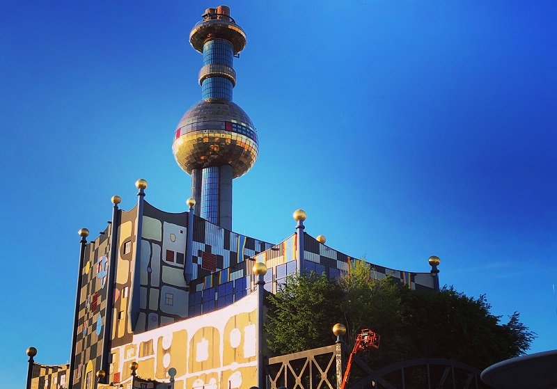Fernwärme Wien Gebäude von Architekt Hundertwasser mit blauem Himmel