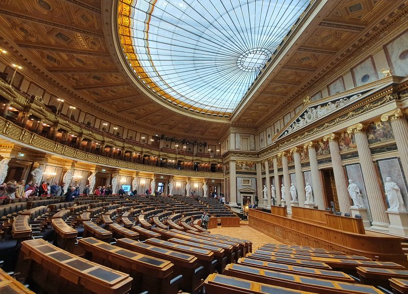 Das Bild zeigt den historischen Sitzungssaal des österreichischen Parlaments.