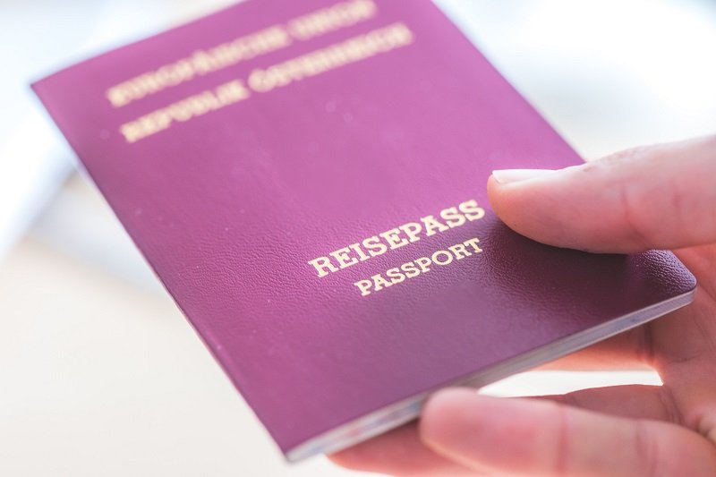 Frau hält österreichischen Reisepass in Hand